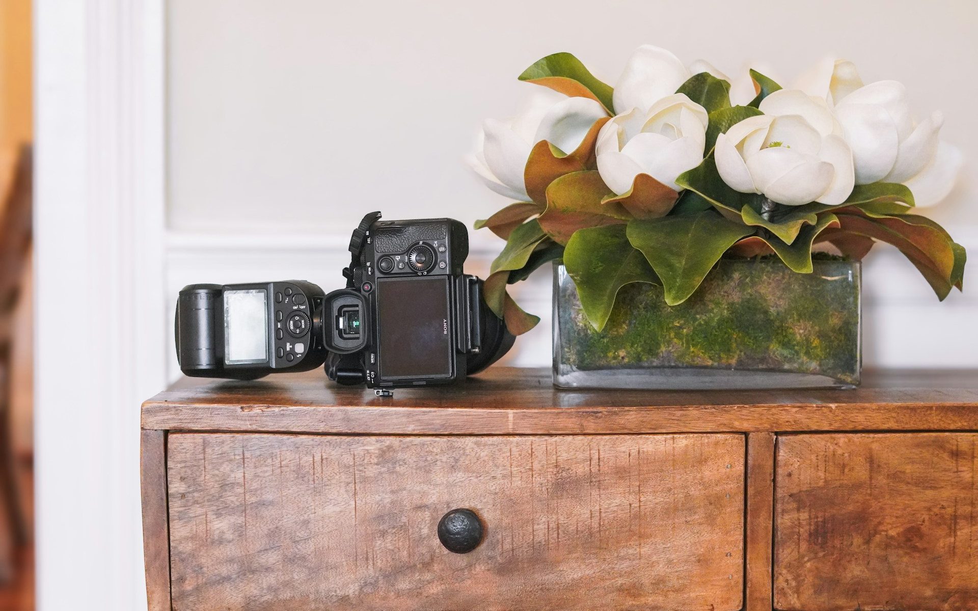 A camera sat next to wedding flowers