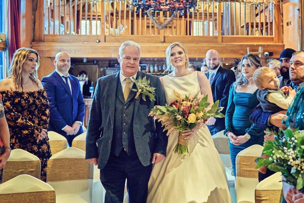 Jenna in a white dress walking down the aisle