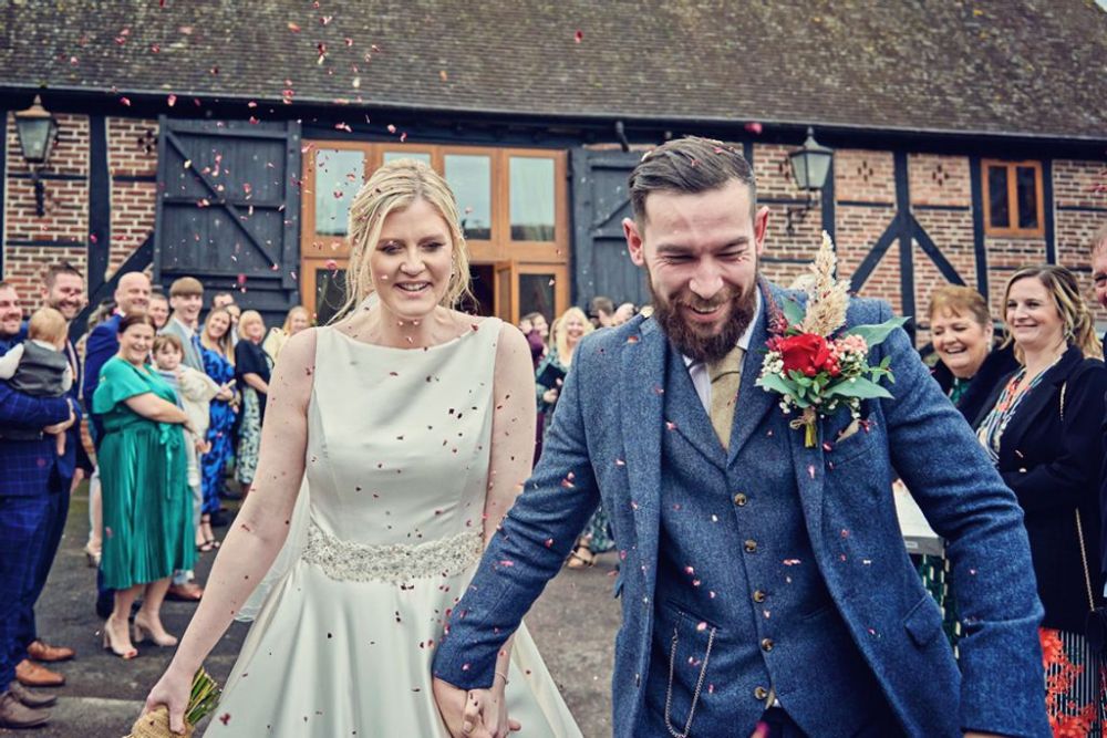 A wedding couple under a shower of confetti