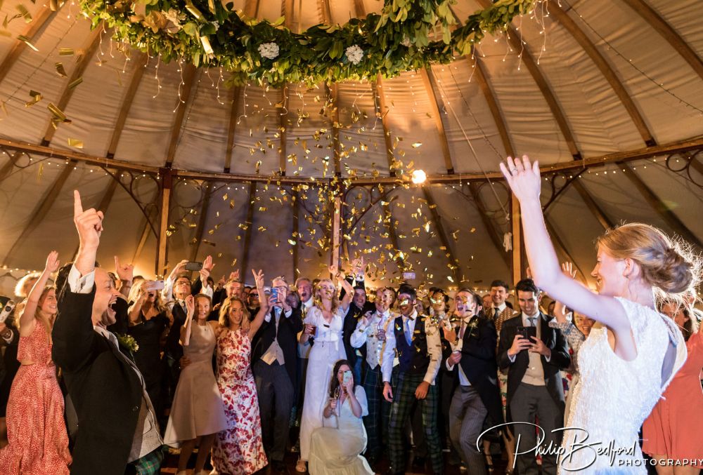 Couple and their guests throwing confetti